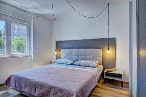 ein Schlafzimmer mit einem großen Bett und einem Fenster in der Unterkunft Lola app in city center, 4+1 pax in Pula