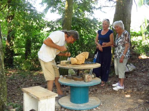a man and two women standing next to a stone table at Le Chant Des Fees in Notre-Dame-de-Courson