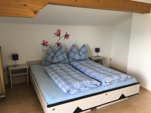 łóżko z niebieską pościelą i poduszkami w pokoju w obiekcie Ferienwohnung Windhof w mieście Abtenau