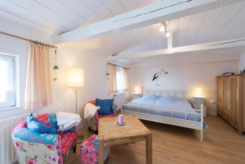 ノルダーナイにあるHaus Albatros App. Storchennestのベッドルーム1室(ベッド1台、ソファ、テーブル付)