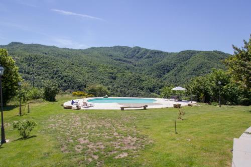 a swimming pool in a field with mountains in the background at Valbuona b&b in Mercatello sul Metauro
