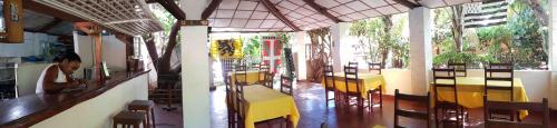 a restaurant with yellow tables and chairs in a room at Le Village Diego in Diego Suarez