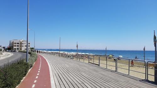 a boardwalk on a beach next to the ocean at ZORBAS Sea View No 4 in Larnaka
