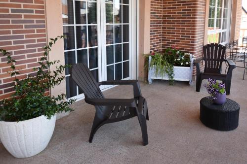 two black chairs sitting on a porch with plants at Los Olivos in Nava de la Asunción