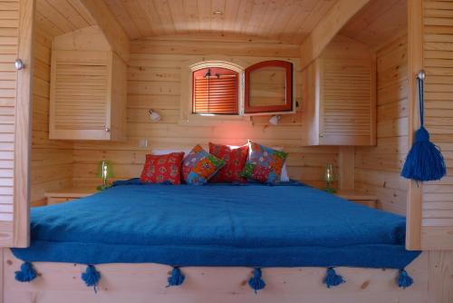 1 dormitorio con 1 cama en una cabaña de madera en Les Piégonnaises - 2 Roulottes, en Piégon