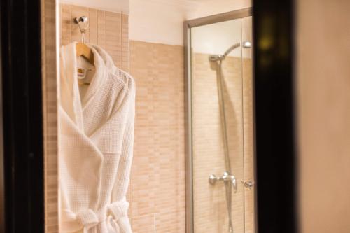a robe hanging in front of a shower in a bathroom at Hotel Almas in Marrakech