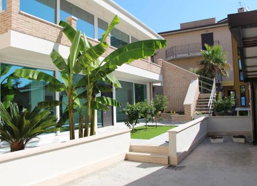 un edificio con una palmera delante de él en la casa dei limoni, en Porto SantʼElpidio