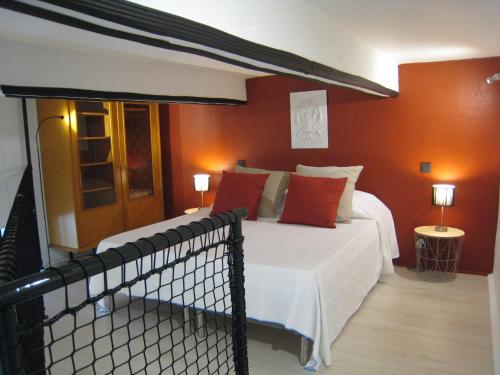une chambre avec un grand lit aux murs rouges dans l'établissement StellaHome - La petite cour, à Sanary-sur-Mer