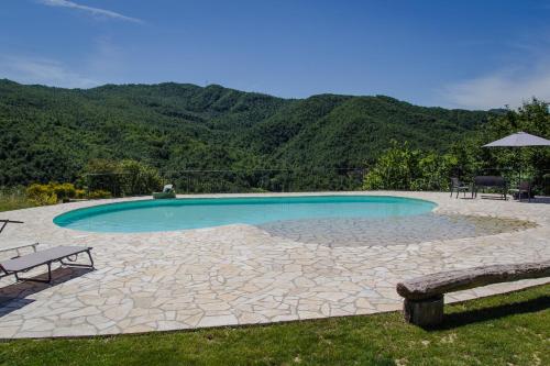 a swimming pool with a table and benches in a yard at Valbuona b&b in Mercatello sul Metauro