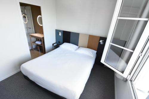a bedroom with a white bed and a ladder at Cit'Hotel De Harlay in Compiègne