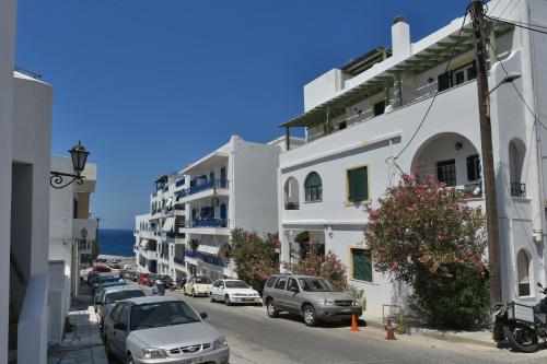 a city street with cars parked in front of buildings at Πικροδάφνες in Tinos Town