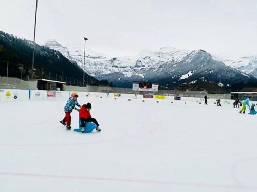 two children playing in the snow on a ski slope at Chalet ELK Lenk in Lenk