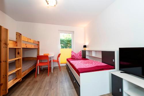 ゲーレンにあるVilla Mia Whg 2 mit Terrasse, EG 1 Raum Wohnungの二段ベッド2台、テーブル、椅子が備わる客室です。
