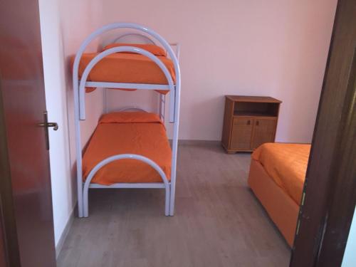 a small room with two bunk beds and a table at La Pinetina in Soverato Marina