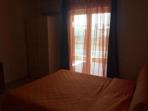 a bedroom with a bed and a window with curtains at La Pinetina in Soverato Marina