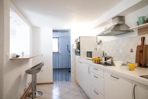a kitchen with white cabinets and a counter top at Nauportus in Vrhnika