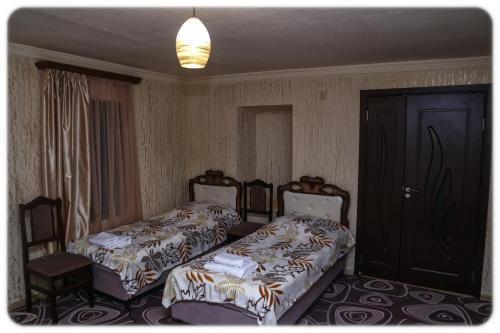 a bedroom with two beds and a door and a room at Lucy B&B in Goris
