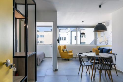 アテネにあるThe Athenians Modern Apartmentsのテーブルと椅子、ベッドルーム1室が備わります。