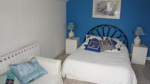 a bedroom with a white bed and blue walls at La petite maison - L'Ouche Charlot in Maux