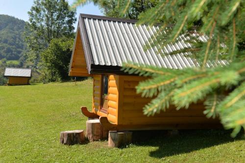a small cabin with a tin roof on a field at Tara Place - Camp Rabrenovic in Mojkovac
