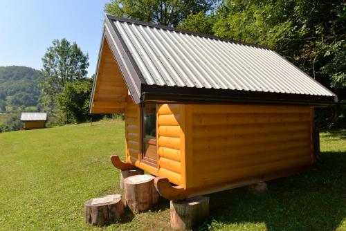 a small dog house on logs in a field at Tara Place - Camp Rabrenovic in Mojkovac