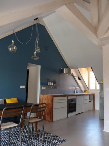 a kitchen with a table and chairs in a room at Le Jardin De Gustave in Ornans