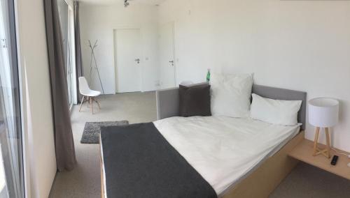a bedroom with a bed with white sheets and pillows at Designer Studio Geestland in Langen