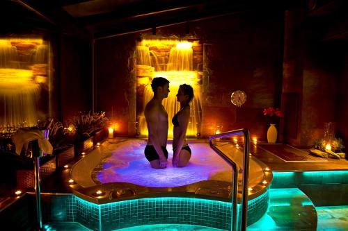 a man and woman standing in a hot tub at Willa Spa Scaliano in Kudowa-Zdrój