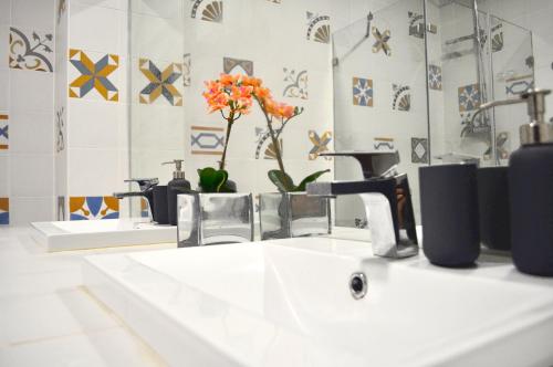 a bathroom sink with a faucet and a mirror at Intendente Terrace in Lisbon