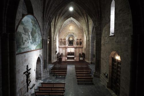 a church with wooden pews and aasteryasteryasteryasteryasteryasteryasteryastery at MONASTERIO de SANTA MARÍA DE VALVANERA in Anguiano