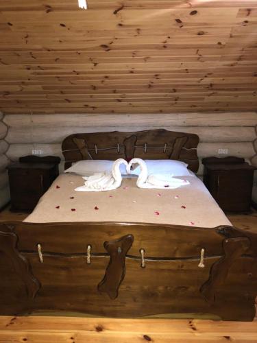 two swans sitting on a bed in a room at Gostynna sadyba Kit Bayun in Teterivka