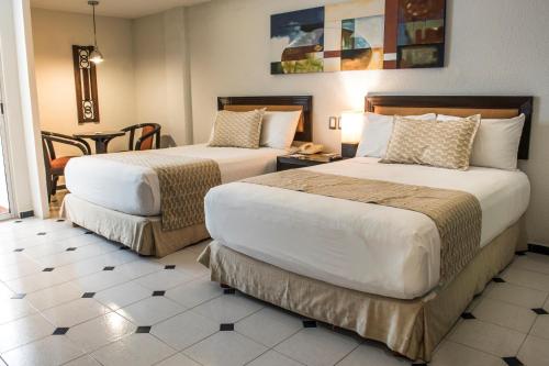 梅里達的住宿－帕賽奧德蒙特霍征服者酒店，酒店客房设有两张床和一张桌子。