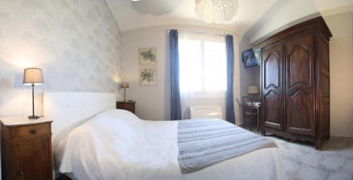um quarto com uma grande cama branca e uma janela em B&B La Campagne em Roquevaire