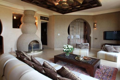 sala de estar con sofá y chimenea en O'Atlas, en El Harkat