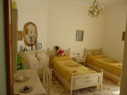 a bedroom with two beds and a mirror at Casa vacanza Manfredonia in Manfredonia