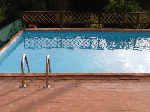 a swimming pool with blue water in a yard at Rifugio di campagna in Vitorchiano