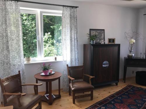 d'un salon avec une table, des chaises et une fenêtre. dans l'établissement Komfortowe Apartamenty Gdynia, à Gdynia