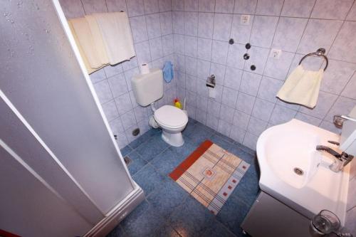 a bathroom with a white toilet and a sink at Vila Izabela in Stara Novalja