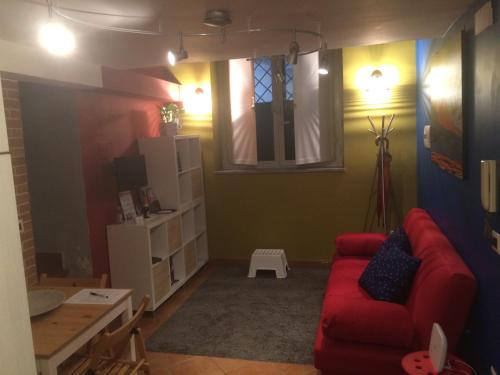 sala de estar con sofá rojo y mesa en Casa Colore, en Nápoles