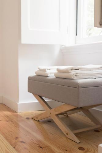 a stack of towels sitting on a bed in a room at Destino Lisboa Apartments in Lisbon