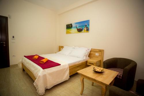 Dormitorio pequeño con cama y mesa en Hotel Albania, en Velipojë