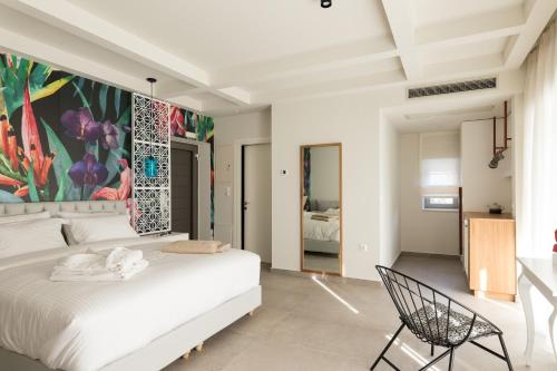 a bedroom with a white bed and a painting on the wall at Anemolia Parga Suites in Sarakiniko