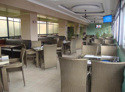 uma sala de jantar com mesas e cadeiras num restaurante em Ash White Hotel em Nairobi
