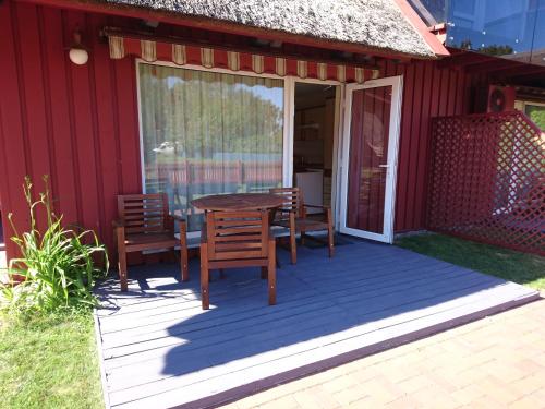 a patio with a table and chairs on a red house at Atostogos Pervalkoje in Pervalka