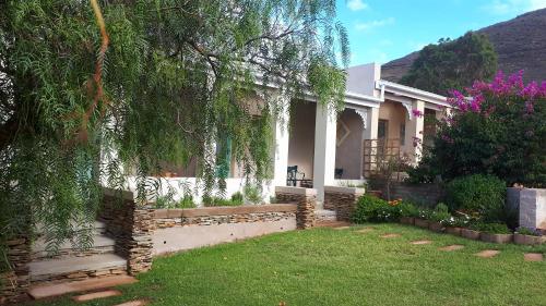a house with a fence in front of a yard at Over Karoo Inn in Barrydale