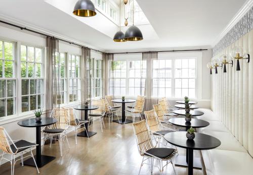 a room with tables and chairs and windows at The Richard, The Edgartown Collection in Edgartown