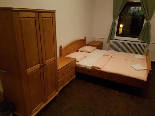 a bedroom with two beds and a cabinet and a window at Penzion Varšavjanka in Harrachov