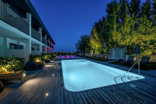 a swimming pool in front of a building at night at Aqua Bay in Plános