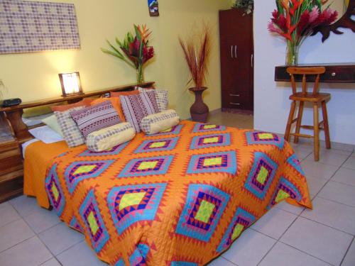 a bed with a colorful blanket and pillows on it at Casa Lima B&B in San José