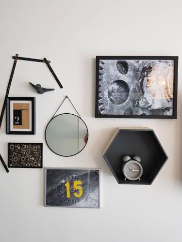 a wall with pictures and a mirror and a clock at Engine rooms in Rijeka